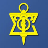 The image displays a yellow emblem with a compass rose at its center, encircled by the text  K.T.  and flanked by two stylized wings on either side. The emblem is set against a blue background.