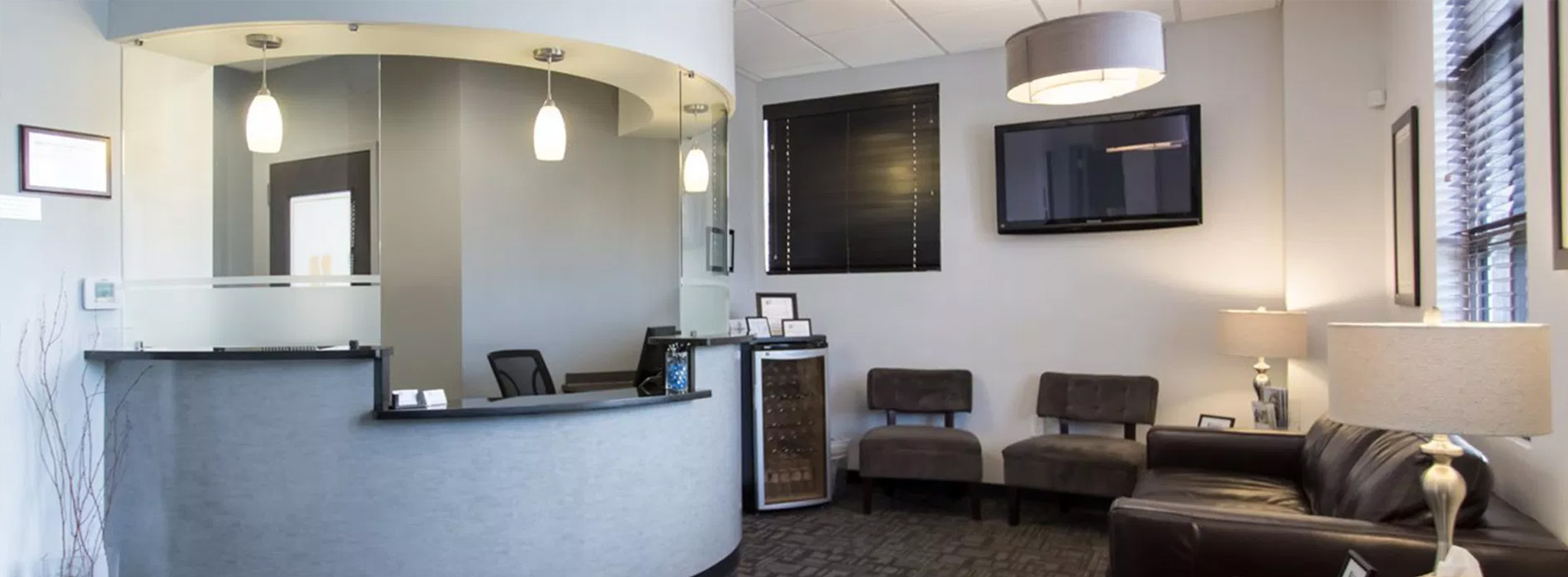 The image shows a modern dental clinic interior with various pieces of equipment, including a dental chair and an X-ray machine.