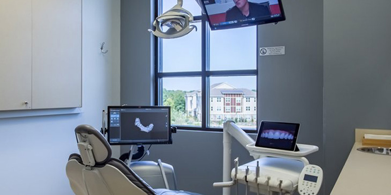The image depicts a modern office reception area with a sleek, contemporary design featuring a wooden desk and a white countertop.
