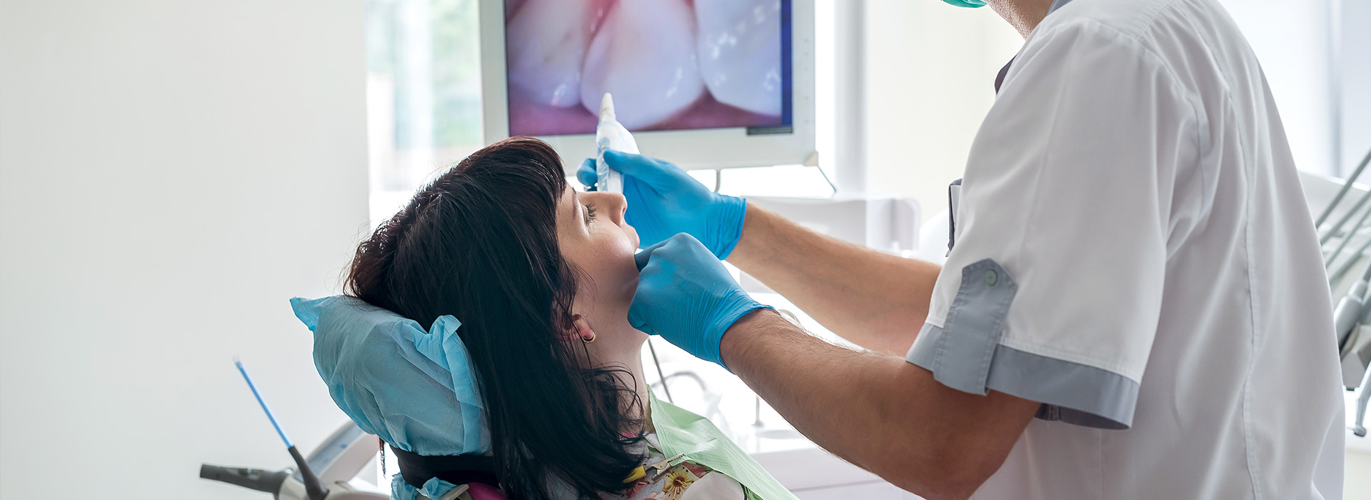 A dental professional performing a procedure on a patient in a clinic setting.